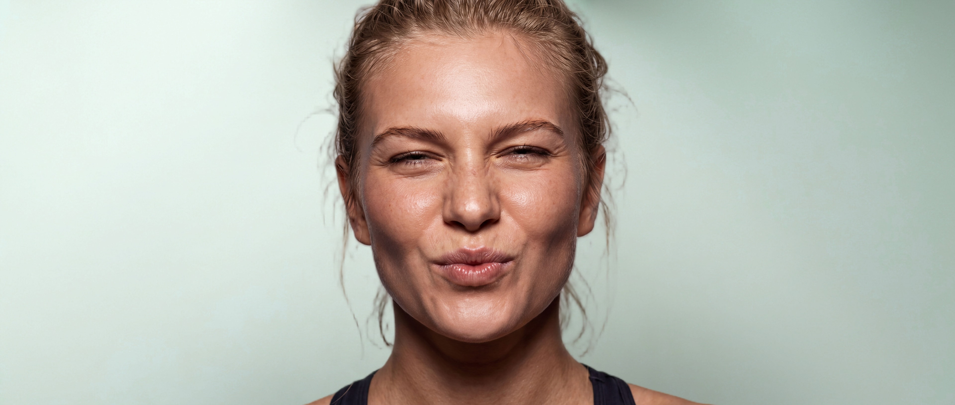 A woman with her eyes squeezed shut, lips pursed